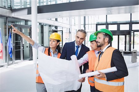 simsearch:614-06814032,k - Businessman discussing on blueprint with architects in office building Stock Photo - Premium Royalty-Free, Code: 6109-08804263