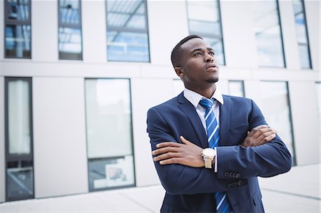 simsearch:6109-08805120,k - Thoughtful businessman with arms crossed standing outside office building Stock Photo - Premium Royalty-Free, Code: 6109-08804282