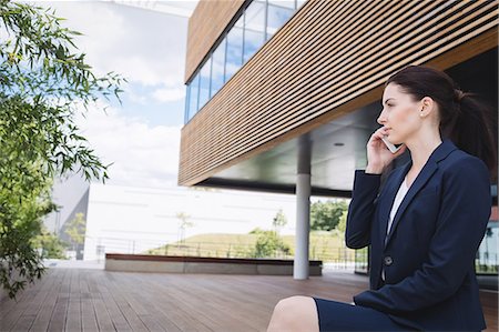 simsearch:6109-08763979,k - Businesswoman sitting outside office building and talking on mobile phone Stock Photo - Premium Royalty-Free, Code: 6109-08804293