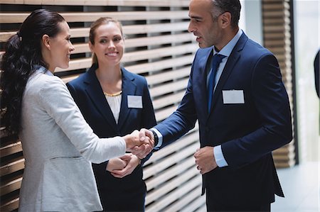 Businesspeople having a discussion and shaking hands in office Stock Photo - Premium Royalty-Free, Code: 6109-08804202