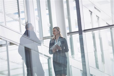 Businesswoman interacting with a colleague in corridor of an office building Stock Photo - Premium Royalty-Free, Code: 6109-08804222