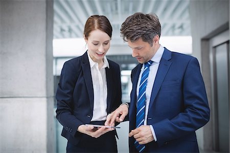 simsearch:6109-08804469,k - Businessman and colleague discussing over digital tablet inside office building Stock Photo - Premium Royalty-Free, Code: 6109-08804238