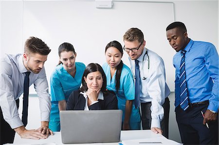 Team of doctor discussing over laptop in meeting at conference room Foto de stock - Sin royalties Premium, Código: 6109-08804376