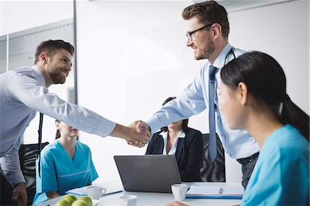 Doctors shaking hands with each other in meeting at conference room Stock Photo - Premium Royalty-Free, Code: 6109-08804386