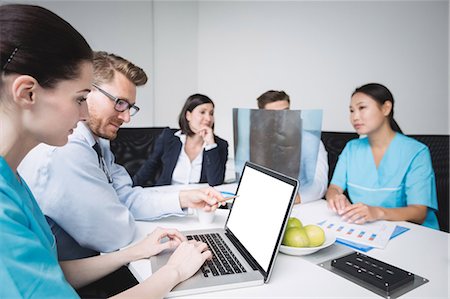 Doctors discussing over laptop in meeting at conference room Foto de stock - Sin royalties Premium, Código: 6109-08804394