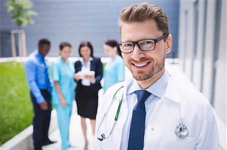 Portrait of smiling doctor standing in hospital premises Stock Photo - Premium Royalty-Free, Code: 6109-08804333