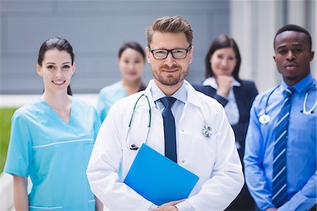 simsearch:6109-08804375,k - Portrait of smiling doctors standing together in hospital premises Stock Photo - Premium Royalty-Free, Code: 6109-08804339