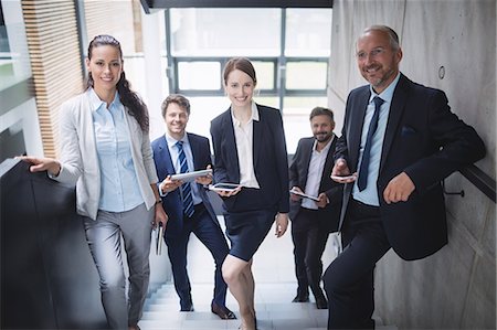 simsearch:6109-08804451,k - Portrait of confident businesspeople standing on staircase in office Stockbilder - Premium RF Lizenzfrei, Bildnummer: 6109-08804450