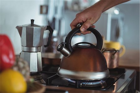 Preparing tea in teakettle on stove in kitchen Foto de stock - Royalty Free Premium, Número: 6109-08804490