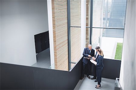 simsearch:6109-08804469,k - Group of businesspeople having a discussion near staircase in office Stock Photo - Premium Royalty-Free, Code: 6109-08804428