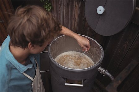 Man testing temperature of beer in wort while making beer at home brewery Stock Photo - Premium Royalty-Free, Code: 6109-08804577