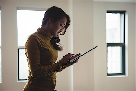 Woman using digital tablet at home Stock Photo - Premium Royalty-Free, Code: 6109-08804767