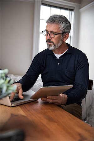 simsearch:6109-08804993,k - Man using laptop in living room at home Fotografie stock - Premium Royalty-Free, Codice: 6109-08804878