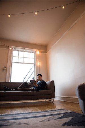 simsearch:6109-08537097,k - Man talking on mobilephone in living room at home Stock Photo - Premium Royalty-Free, Code: 6109-08804897