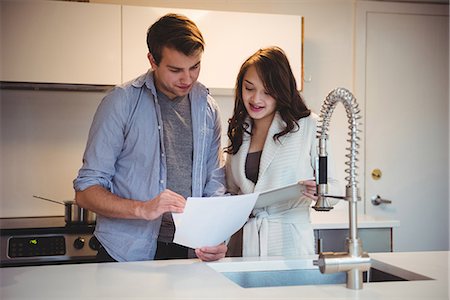 dialog at home man woman - Couple discussing over digital tablet in kitchen at home Stock Photo - Premium Royalty-Free, Code: 6109-08804807