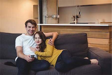 simsearch:6109-08804832,k - Smiling couple sitting on a sofa watching TV in living room at home Stock Photo - Premium Royalty-Free, Code: 6109-08804816