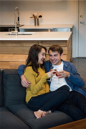 simsearch:6109-08804832,k - Couple drinking red wine while sitting on the sofa in living room at home Stock Photo - Premium Royalty-Free, Code: 6109-08804832