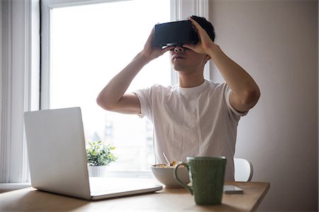 simsearch:6109-08944595,k - Man using virtual reality headset in living room at home Photographie de stock - Premium Libres de Droits, Code: 6109-08804975
