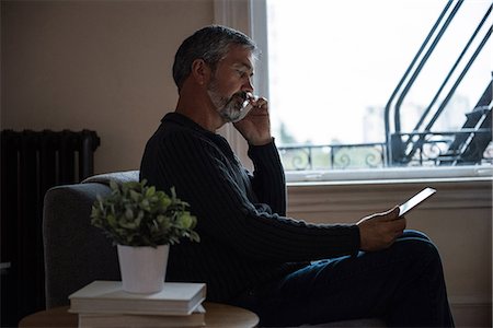 simsearch:6109-08537136,k - Man talking on mobilephone in living room at home Foto de stock - Sin royalties Premium, Código: 6109-08804994