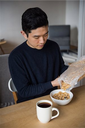 simsearch:6109-08944595,k - Man pouring cereals in bowl at home Photographie de stock - Premium Libres de Droits, Code: 6109-08804913