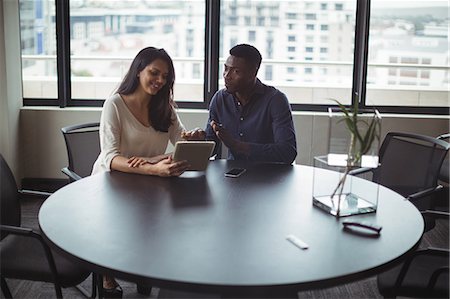 simsearch:6109-08805114,k - Businessman and a colleague discussing over digital tablet in office Foto de stock - Royalty Free Premium, Número: 6109-08805055