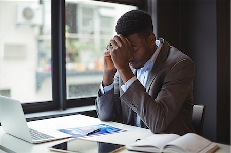 sad black person computer - Stressed businessman sitting at his desk in office Photographie de stock - Premium Libres de Droits, Code: 6109-08805079