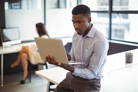 simsearch:6109-08805114,k - Businessman working over laptop in office Foto de stock - Royalty Free Premium, Número: 6109-08805092