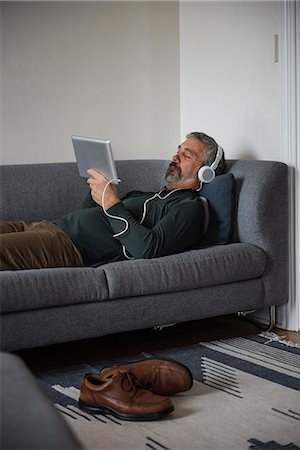 simsearch:6109-08804993,k - Man listening music on digital tablet at home Fotografie stock - Premium Royalty-Free, Codice: 6109-08805019