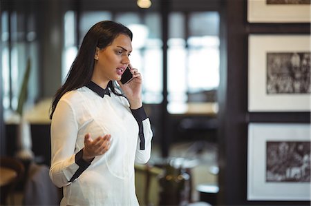 simsearch:6109-08763962,k - Businesswoman talking on mobile phone in office Stock Photo - Premium Royalty-Free, Code: 6109-08805140