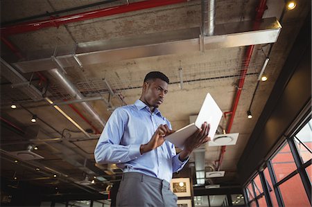 simsearch:6109-08805114,k - Businessman working over laptop in office Foto de stock - Royalty Free Premium, Número: 6109-08805149