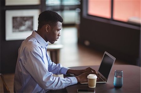 photos of black people in a computer class - Businessman using laptop in office Stock Photo - Premium Royalty-Free, Code: 6109-08805155