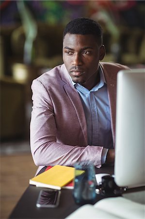 simsearch:6109-08805120,k - Thoughtful businessman looking away in office Stock Photo - Premium Royalty-Free, Code: 6109-08805167