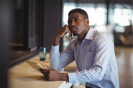 Businessman using digital tablet in office Stock Photo - Premium Royalty-Free, Code: 6109-08805185