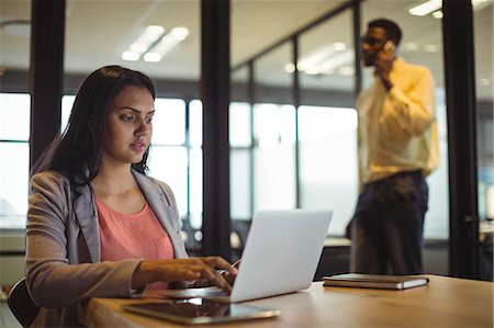 simsearch:6109-08805110,k - Businesswoman working over laptop in office Photographie de stock - Premium Libres de Droits, Code: 6109-08805132