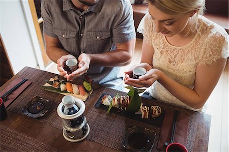 sushi - Couple having sake while eating sushi Photographie de stock - Premium Libres de Droits, Code: 6109-08829553