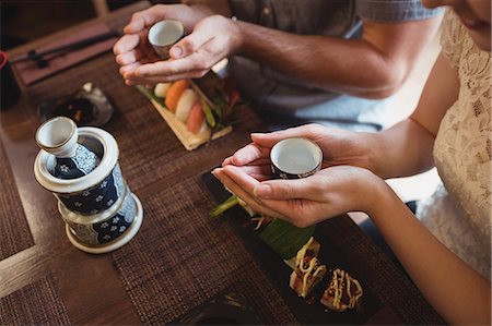 set de table - Couple having sake while eating sushi Photographie de stock - Premium Libres de Droits, Code: 6109-08829554