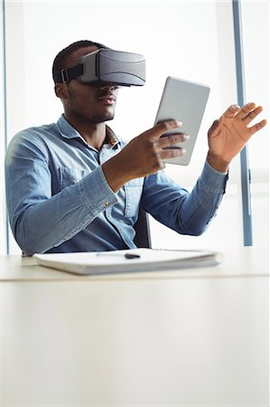 simsearch:6109-08701397,k - Business executive using virtual reality headset and digital tablet Stock Photo - Premium Royalty-Free, Code: 6109-08829636