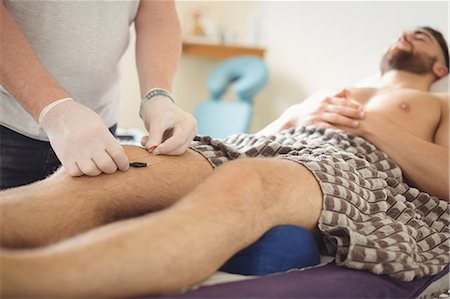 simsearch:6109-08829776,k - Physiotherapist performing dry needling on the knee of a patient Fotografie stock - Premium Royalty-Free, Codice: 6109-08829764