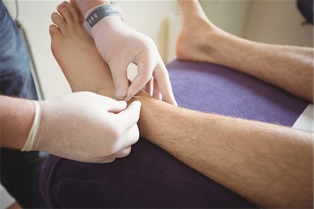 Physiotherapist performing dry needling on the leg of a patient Stock Photo - Premium Royalty-Free, Code: 6109-08829772