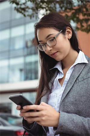 simsearch:6109-08829709,k - Businesswoman text messaging on mobile phone Stock Photo - Premium Royalty-Free, Code: 6109-08829731