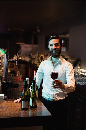 simsearch:6109-08944150,k - Portrait of Bartender holding glass of red wine Foto de stock - Royalty Free Premium, Número: 6109-08829840