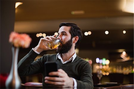 simsearch:6109-08782736,k - Man holding mobile phone and having a drink Stock Photo - Premium Royalty-Free, Code: 6109-08829883