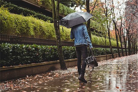 rainy season man walking - Man with handbag and umbrella walking on pedestrian walkway Stock Photo - Premium Royalty-Free, Code: 6109-08829940