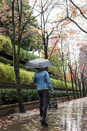 rainy season man walking - Man with handbag and umbrella walking on pedestrian walkway Stock Photo - Premium Royalty-Free, Code: 6109-08829947