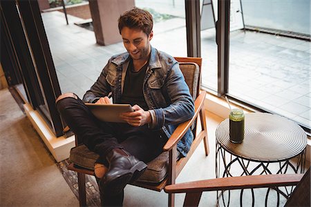 Man using digital tablet in café̩ Photographie de stock - Premium Libres de Droits, Code: 6109-08829945