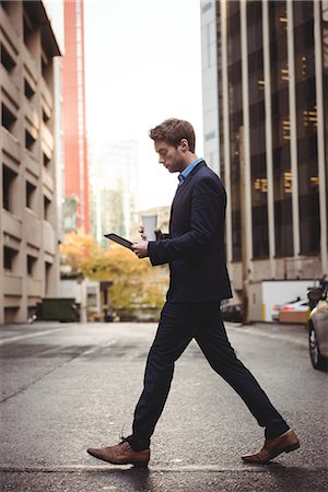 simsearch:6109-08689749,k - Businessman using digital tablet while crossing the street Photographie de stock - Premium Libres de Droits, Code: 6109-08829960