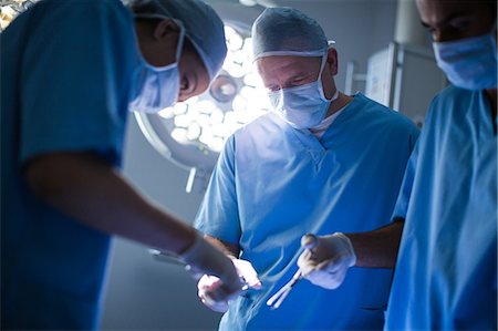 simsearch:6109-08389797,k - Group of surgeons performing operation in operation room Stock Photo - Premium Royalty-Free, Code: 6109-08829992