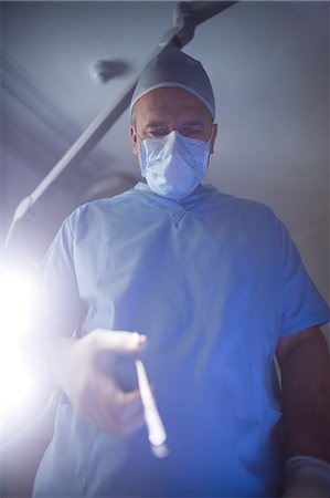 simsearch:6109-08389797,k - Surgeon performing operation in operation room Stock Photo - Premium Royalty-Free, Code: 6109-08829995