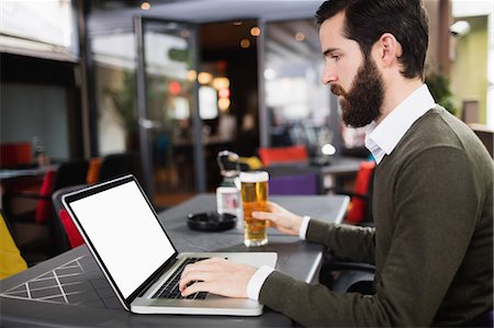 simsearch:6109-08782623,k - Man using laptop while having glass of beer Stock Photo - Premium Royalty-Free, Code: 6109-08829903