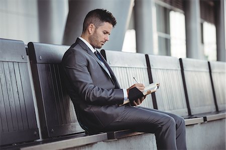 simsearch:6109-08805120,k - Businessman writing in his diary while sitting on a bench Stock Photo - Premium Royalty-Free, Code: 6109-08830043